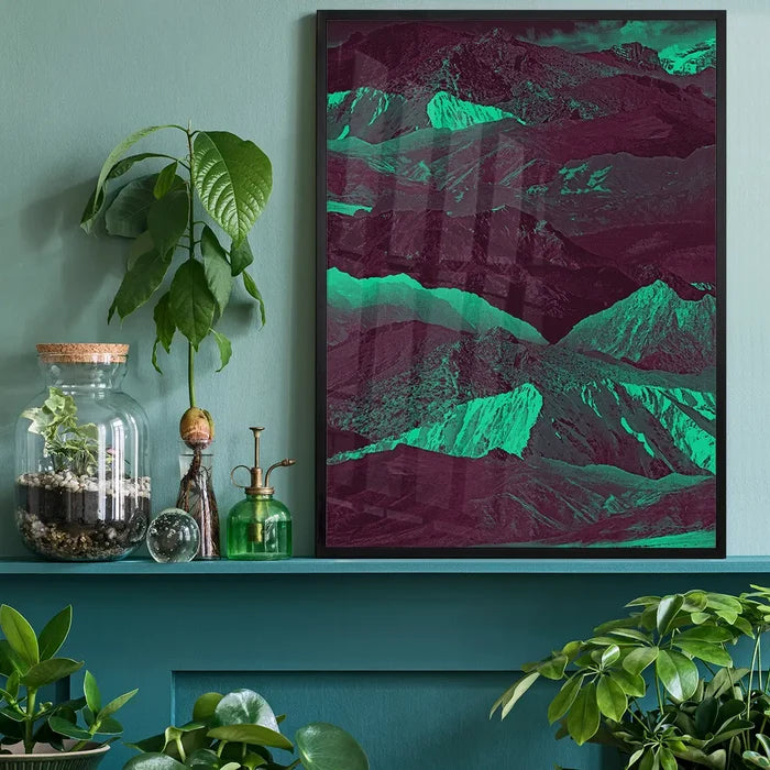 Abstract Mountains 1 print with bold green and purple hues in a black frame, displayed on a teal shelf.