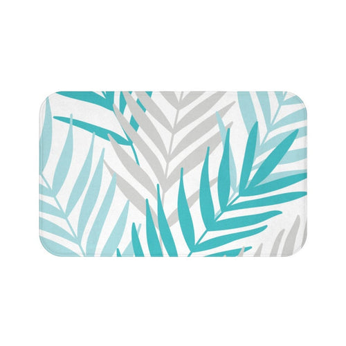 A rectangular memory foam mat featuring a pattern of aqua and gray palm leaves on a white background with an anti-slip backing.