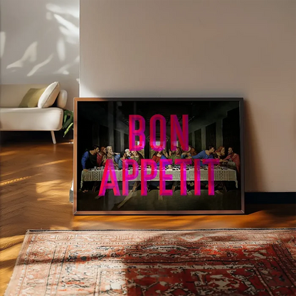 Framed Last Supper print with "BON APPETIT" in bold pink typography, leaning on a wall above a patterned rug.