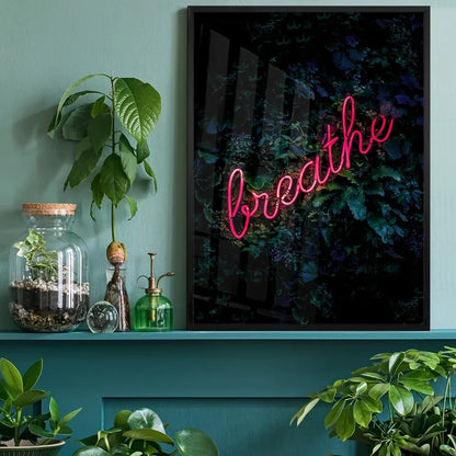 Breathe" neon sign print with vibrant pink script on a dark botanical background, framed in black.