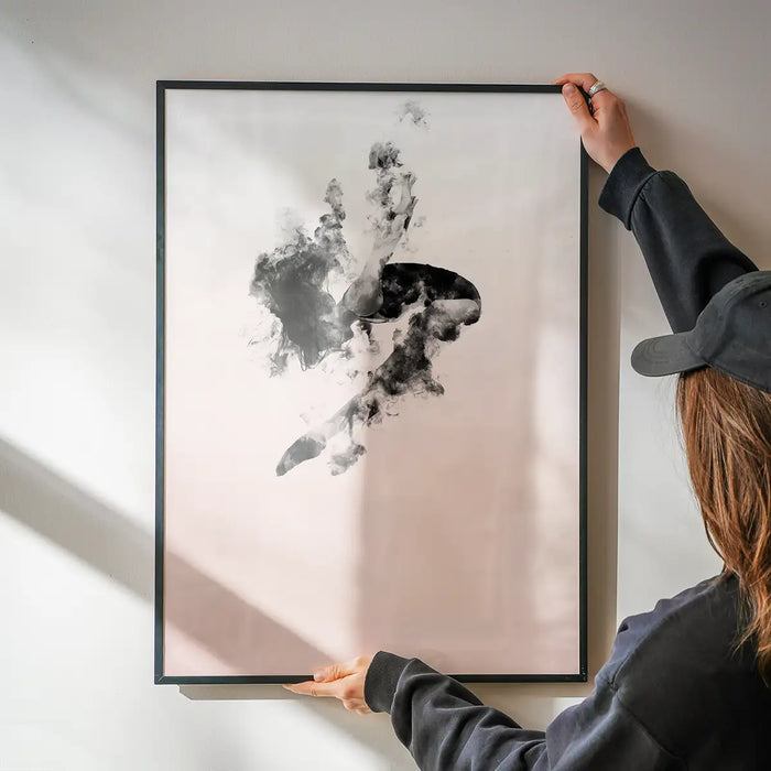 Abstract female form dancing in clouds on pastel pink art print, held by hands.