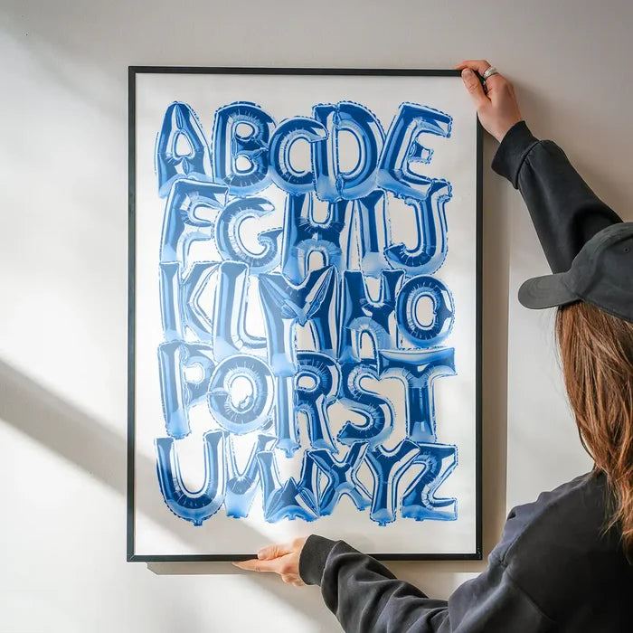 Framed educational print with blue foil balloon-style alphabet letters A-Z on a white background.
