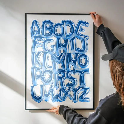 Framed educational print with blue foil balloon-style alphabet letters A-Z on a white background.