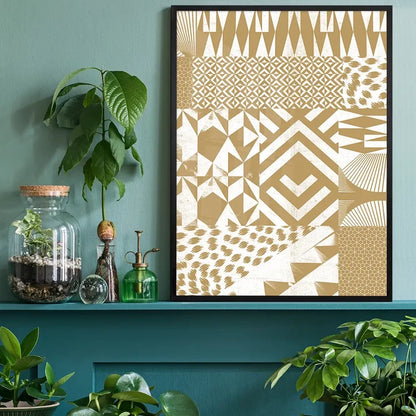 Gold geometric segments print in a black frame, displayed on a teal shelf with plants.
