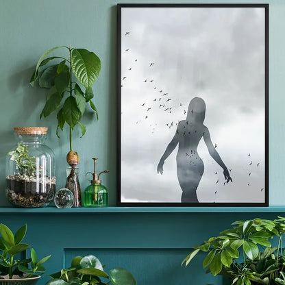 Striking graphic print of a female silhouette with a flock of birds against a cloudy sky, framed in black.