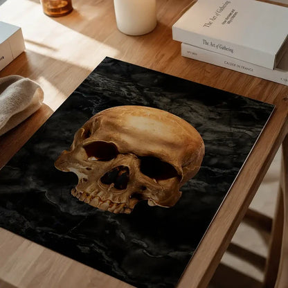 Gold skull graphic print on dark marble background, displayed on a wooden table.