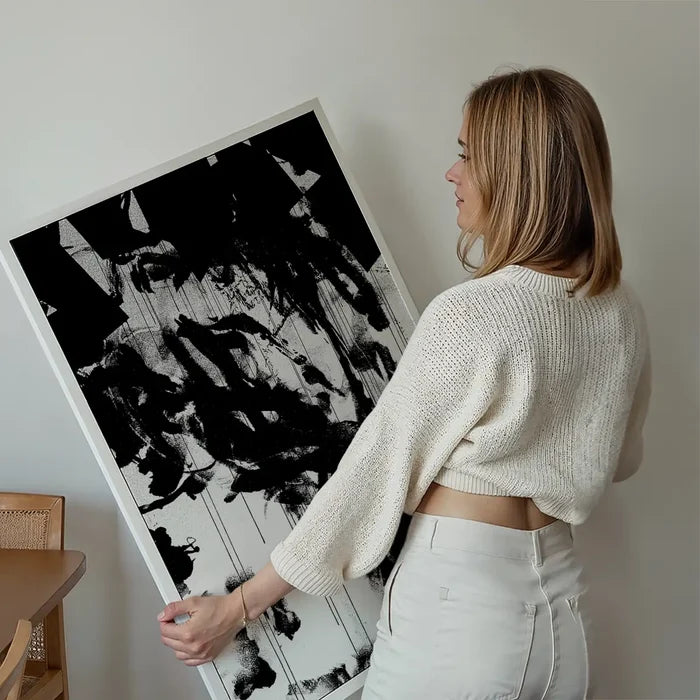 Woman holding a large "Graffiti Girl 1" abstract black and white urban art print on thick paper.