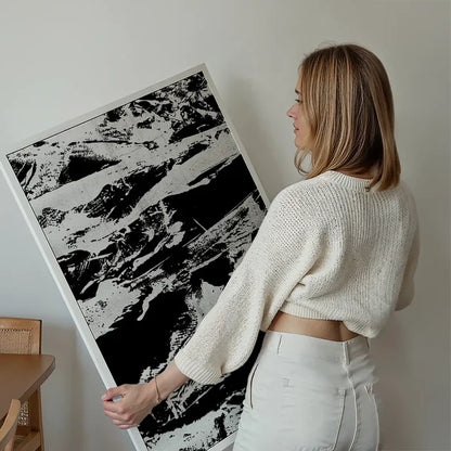 Woman holding a framed Inky 1 Graffiti Print, a bold black and white abstract art print.