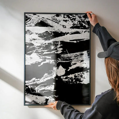 Person hanging a framed Inky 1 Graffiti Print, a bold black and white abstract art print on thick paper.
