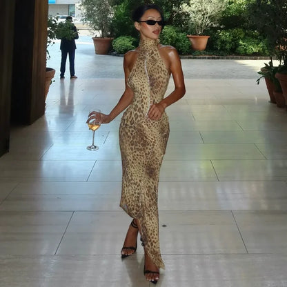 Woman in a leopard print dress holding a glass of wine on a tiled floor.