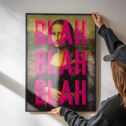 Framed Mona Lisa print with bold pink "BLAH BLAH BLAH" typography overlay, held against a white wall.