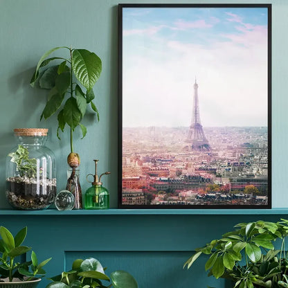 Pink-hued Paris Eiffel Tower city photography print in a black frame, displayed on a teal shelf.