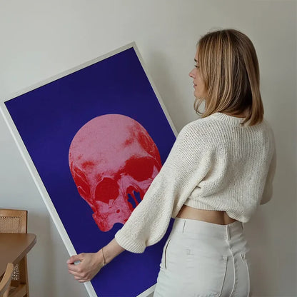 Woman holding large Pop Art Warhol style blue & pink skull print on thick art paper.