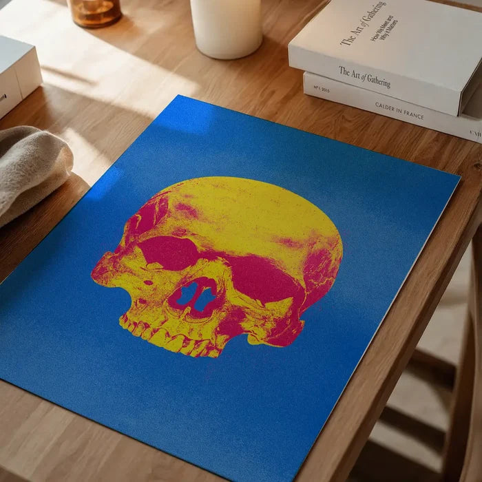 Pop Art Warhol style blue and yellow skull print on thick art paper, displayed on a wooden table.