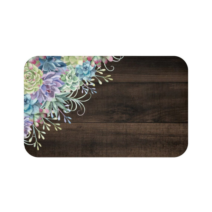A rectangular memory foam mat with a floral pattern on a brown background, featuring a variety of green and purple flowers and decorative elements.