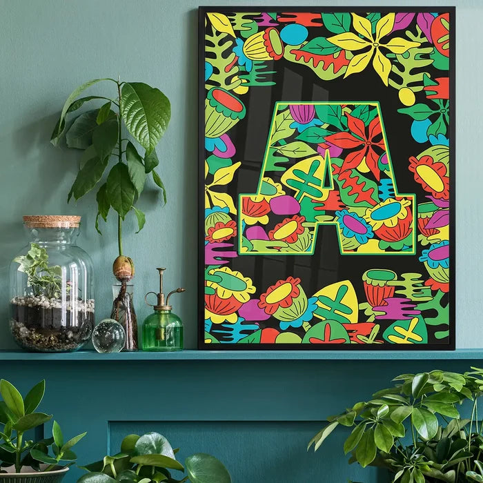 Black framed poster with a bold green "A" filled with vibrant, playful leafy patterns on a black background.