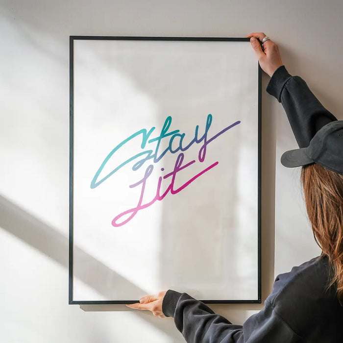 Framed "Stay Lit" quote print on white archival paper, featuring a vibrant teal to pink gradient script.