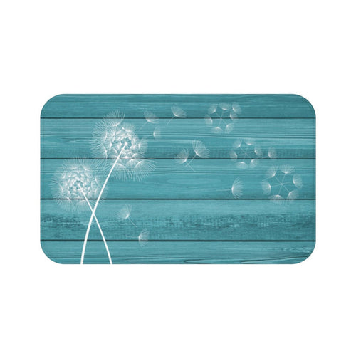 A rectangular memory foam mat with a teal background and a white dandelion design.