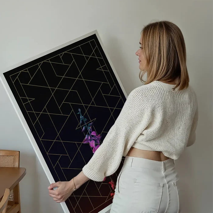 Tall flower print with purple blooms, gold geometric lines on black, held by a woman.