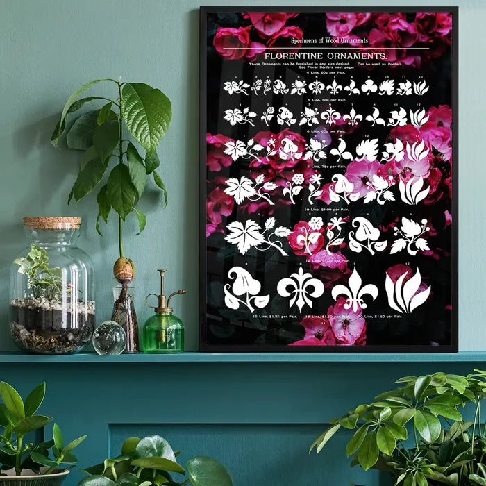 Black framed typographic floral print with white ornaments on a dark pink rose background, displayed on a teal shelf.