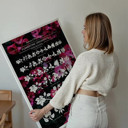 Woman holding a large "Florentine Ornaments" typographic print with pink floral designs on black archival paper.