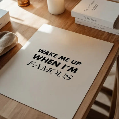 Wake Me Up When I'm Famous" typographic quote print on thick, light beige archival art paper, displayed on a wooden table.