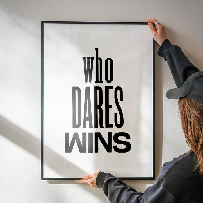 Black framed "Who Dares Wins" quote print on white archival art paper, held by a person.